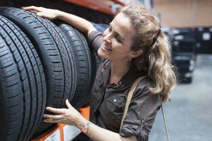 Woman choosing car tire for her vehicle